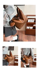 Détail du sac cabas marron vintage avec pendentif ours en peluche mignon et texture