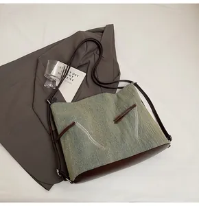 Detail of vintage canvas tote bag featuring premium leather trim and dual zipper texture