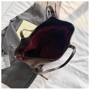 Vista dall'alto della borsa tote marrone scuro con fodera bordeaux e tasca interna