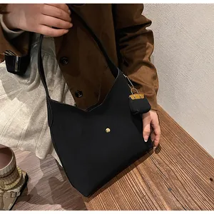 Minimalist black tote bag detail with deep V-cut opening and golden stud decoration