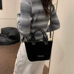 Retro black suede bucket bag with stylish knotted handles and adjustable crossbody strap