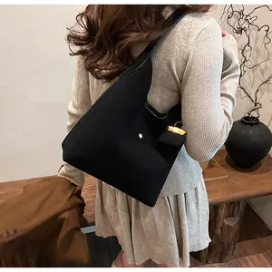 Detail of black Hobo tote bag showing the gold padlock charm and soft matte finish