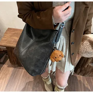Grand sac seau rétro gris avec coutures verticales et breloque en peluche pour femme