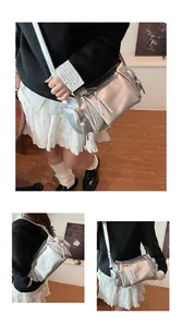 Sac bandoulière argenté métallisé en forme de cylindre avec zips à pompons sur mannequin