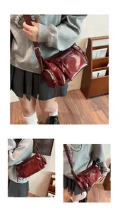 Détail du sac bandoulière vintage rouge foncé en cuir délavé avec plusieurs fermetures éclair