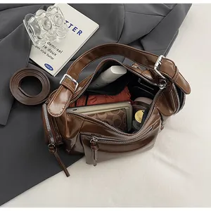 Vue de dessus de l'intérieur spacieux et des poches zippées d'un sac porté épaule marron