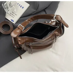 Vue de dessus montrant la capacité intérieure et les fermetures éclair de ce sac marron