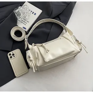 Vue de dessus d'un sac à bandoulière vintage crème avec plusieurs poches et détails