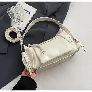 Vue détaillée du sac porté épaule crème en cuir souple avec zips et bandoulière