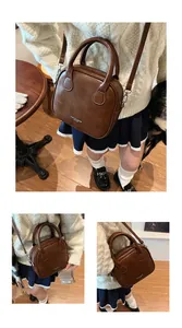 Details der braunen Vintage-Umhängetasche mit Steppmuster und Doppelgriffen im Retro-Stil