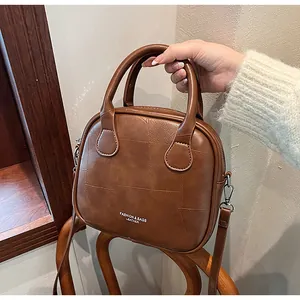 Close-up of brown vintage leather pillow bag with grid stitching and silver hardware detail