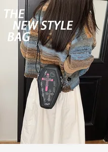 Detail of coffin-shaped gothic crossbody bag with pink cross and heart pattern