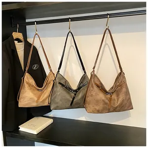 Three multi-color retro tote bags hanging on a rack showing texture and buckle details