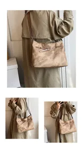 Detail view of large vintage brown hobo bag showing faux leather texture and metal buckles