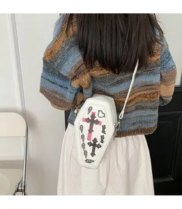 Detail of coffin-shaped crossbody bag with gothic cross prints and Baby Baby text