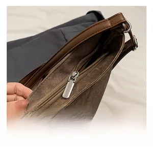 Detail of silver metal zipper and brown leather trim on the large canvas tote bag