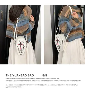 Detailed view of coffin-shaped shoulder bag with cross print and zip closure