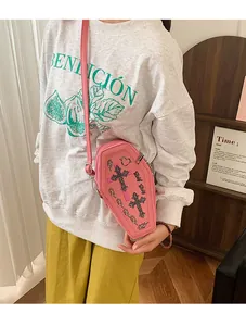 Pink coffin-shaped PU leather crossbody bag with rhinestone crosses shown on a model