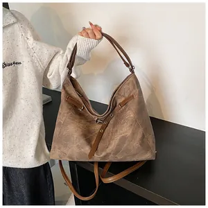 Detail of vintage brown tote bag showing textured surface and versatile double straps