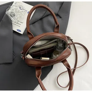 Interior view of vintage brown crossbody bag showing spacious capacity and inner pockets