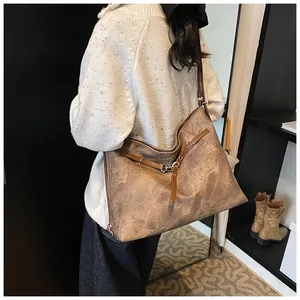 Detail of vintage coffee brown leather tote bag with decorative buckle and long straps