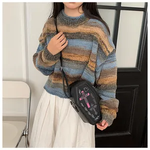 Gothic coffin crossbody bag with pink cross embroidery styled with a striped sweater