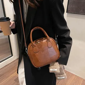 Vintage brown patchwork crossbody pillow bag for women with dual handles and silver hardware