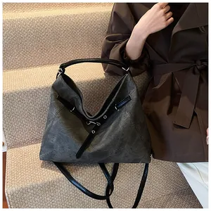 Close-up of charcoal grey tote bag featuring leather straps and metal eyelet details