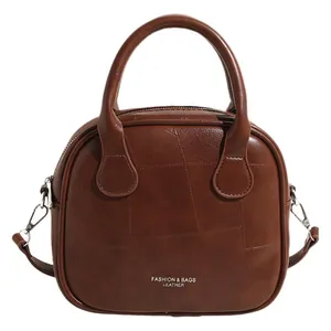 Brown quilted leather top handle bag for women with vintage cross body strap design