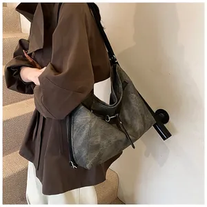 Detail showing high-capacity retro shoulder bag with washed leather texture and metal rings