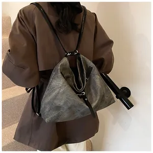Detail of dark grey retro leather bag on model showing washed texture and versatile straps