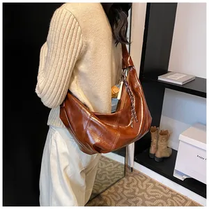 Vista lateral del bolso hobo de cuero encerado caramelo con cordón trenzado