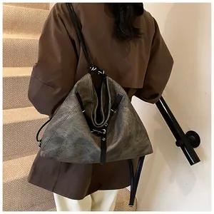 Close-up of a large grey vintage tote bag with textured finish and thin black straps