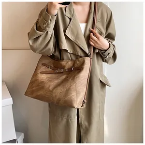 Close-up of the dark brown textured large capacity tote bag worn as a shoulder bag