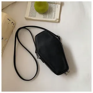Flat lay of a gothic coffin-shaped black crossbody bag with silver zipper detail