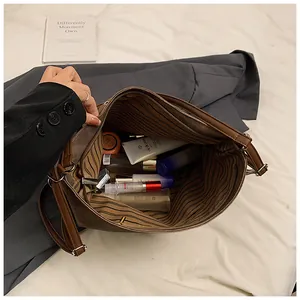 Detail view of large dark brown suede tote bag with striped lining and spacious interior