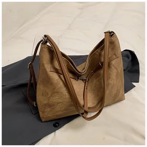 Macro detail of vintage brown leather tote bag with metallic buckle and textured surface