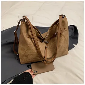 Macro shot of large brown vintage tote bag showing matte texture and side strap detail