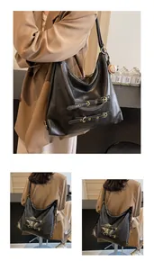 Detail of vintage black Hobo bag featuring matte leather texture and metal buckle straps