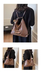 Detail of a brown vintage leather tote bag converted into a backpack with gold hardware