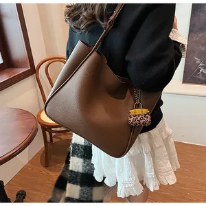 Brown lychee leather tote bag with stylish leopard print mini bag charm on strap