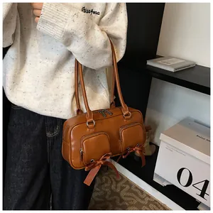 Close-up of vintage brown shoulder bag featuring chic bow accents and dual front pockets