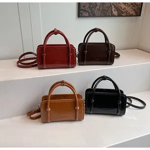 Multi-color collection of vintage contrast boston bags in deep red, brown, and black colors