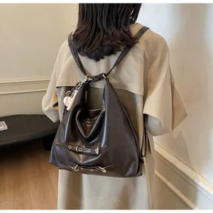 Detail of dark brown vintage backpack showing soft faux leather texture and baseball charm