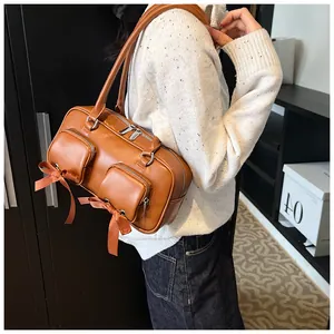 Detail of vintage brown shoulder bag with bow accents and double front zipper pockets