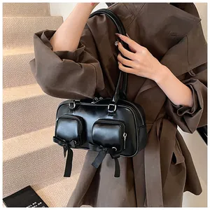 Close-up of black matte PU leather bag featuring front pockets and silk bow details