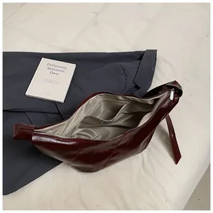 Interior del bolso de cuero burdeos con forro gris y bolsillo con cremallera