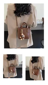 Détails du sac seau vintage marron avec rivets dorés et porte-clés monstre en peluche