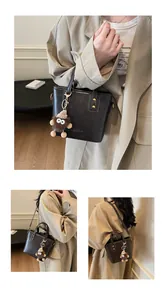 Gros plan sur le sac en cuir poli marron foncé avec rivets métalliques et charm monstre