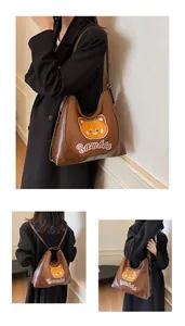 Détail du sac fourre-tout marron vintage avec broderie ours et bandoulière chaîne